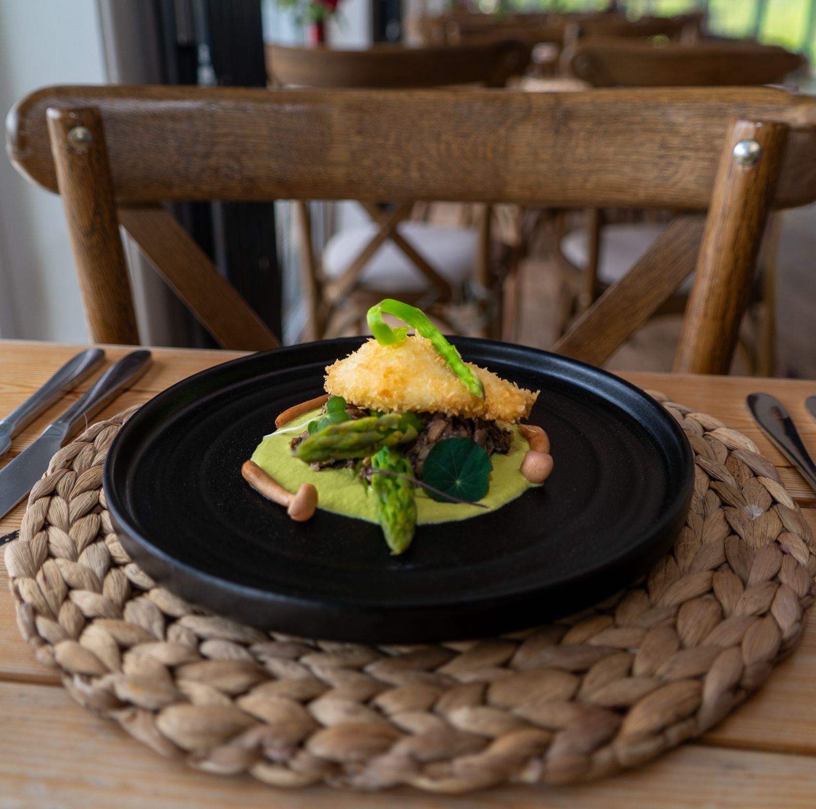 Crispy breaded egg on pea purée with asparagus and mushrooms
