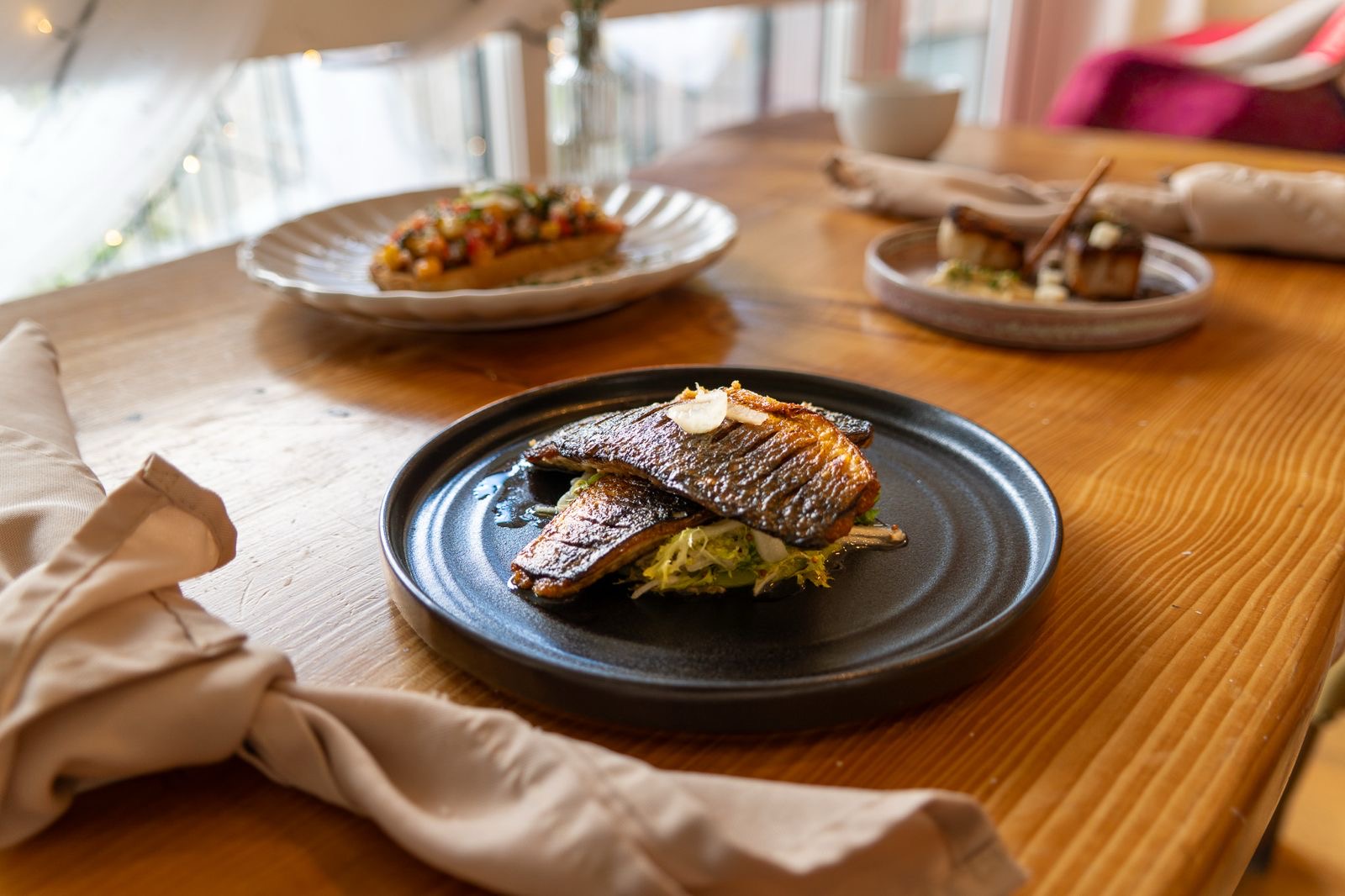 Crisp-skinned fish fillets on dressed leaves