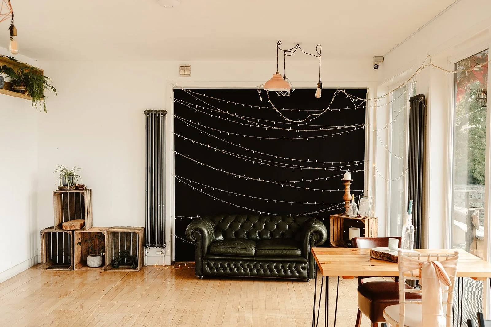 Fairy-lit lounge area with leather sofa and rustic styling