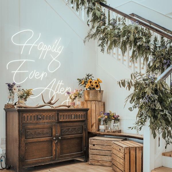 Happily Ever After neon sign with foliage on the staircase